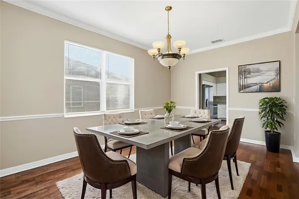 a view of a dining room with furniture a chandelier and wooden floor