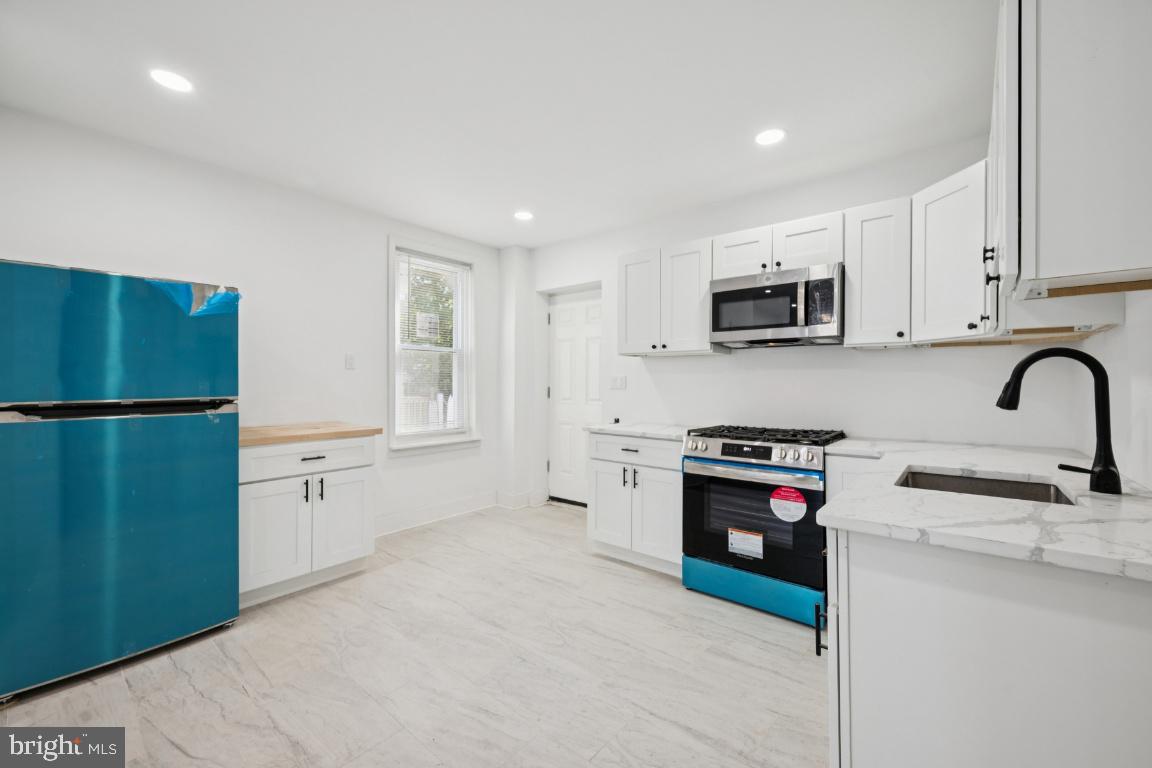 718 Spruce Street Camden, NJ 08103 - Photo 23 of 39 a kitchen with stainless steel appliances granite countertop a refrigerator sink and stove