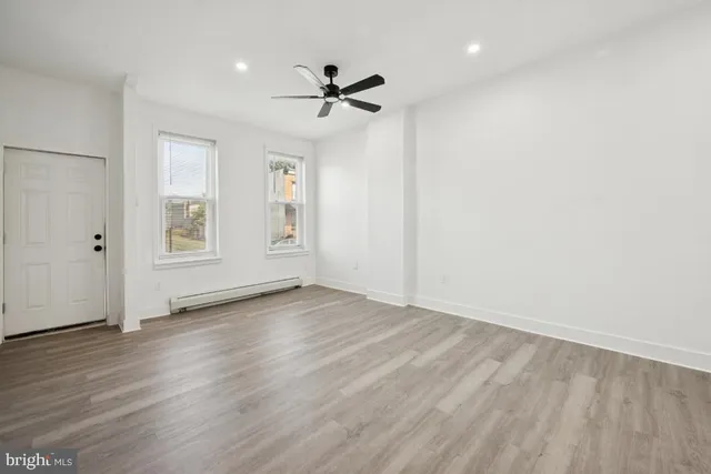 a view of a livingroom with wooden floor and stairs
