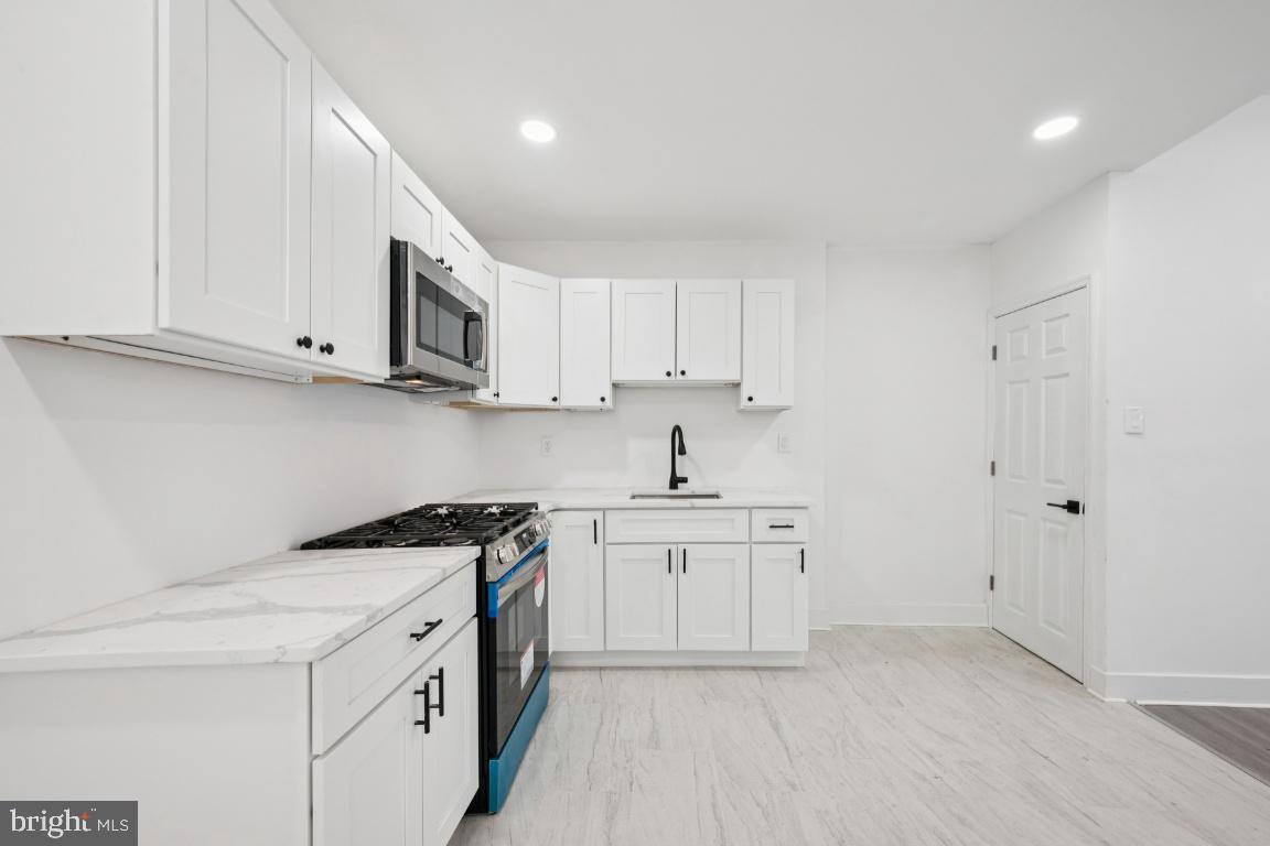 718 Spruce Street Camden, NJ 08103 - Photo 28 of 39 a kitchen with stainless steel appliances granite countertop a sink a stove and a refrigerator
