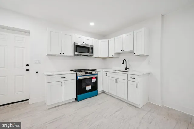a kitchen with cabinets stainless steel appliances a sink and a stove