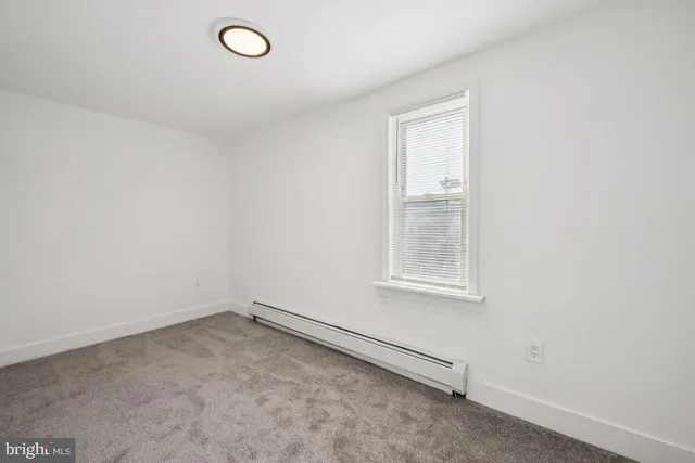 an empty room with wooden floor ceiling fan and windows