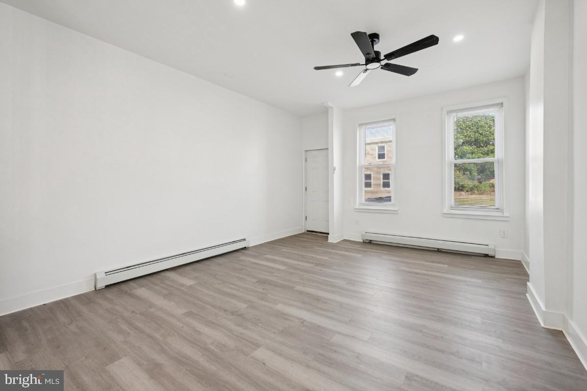 718 Spruce Street Camden, NJ 08103 - Photo 37 of 39 an empty room with wooden floor ceiling fan and windows