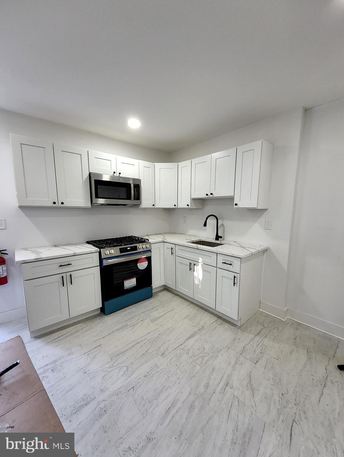 718 Spruce Street Camden, NJ 08103 - Photo 38 of 39 a kitchen with sink a microwave and cabinets