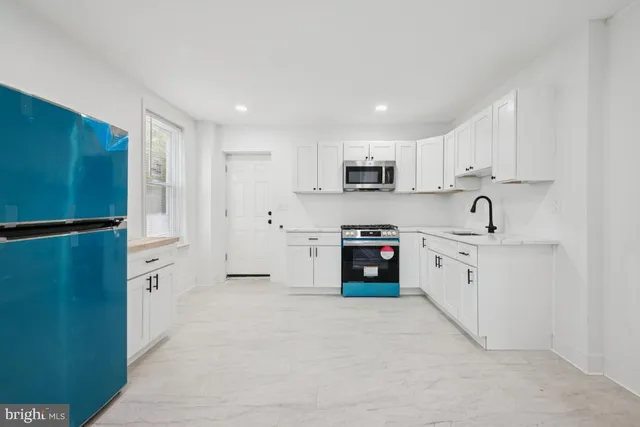 a kitchen with white cabinets and stainless steel appliances