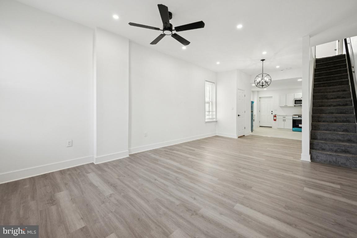 718 Spruce Street Camden, NJ 08103 - Photo 7 of 39 an empty room with wooden floor ceiling fan and windows
