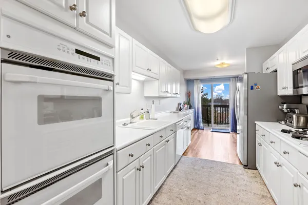 a large white kitchen with cabinets