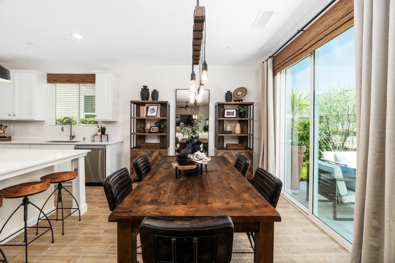 1150 Encore Way West Madera, CA 93636 - Photo 13 of 33 a dining room with a table chairs and a floor to ceiling window