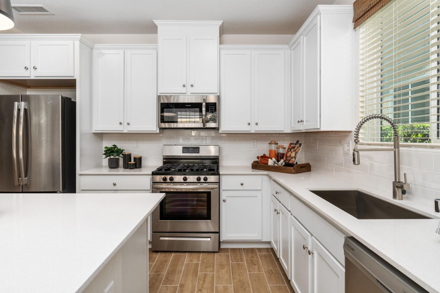 1150 Encore Way West Madera, CA 93636 - Photo 15 of 33 a kitchen with white cabinets sink and stainless steel appliances