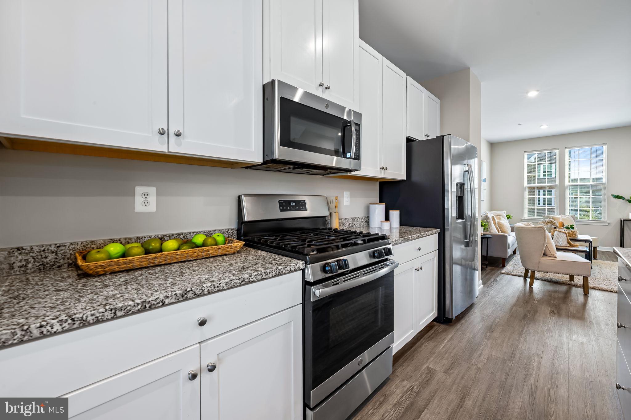8206 Kirk Farm Circle Windsor Mill, MD 21244 - Photo 11 of 35 a kitchen with granite countertop stainless steel appliances a stove a microwave a refrigerator a sink and cabinets