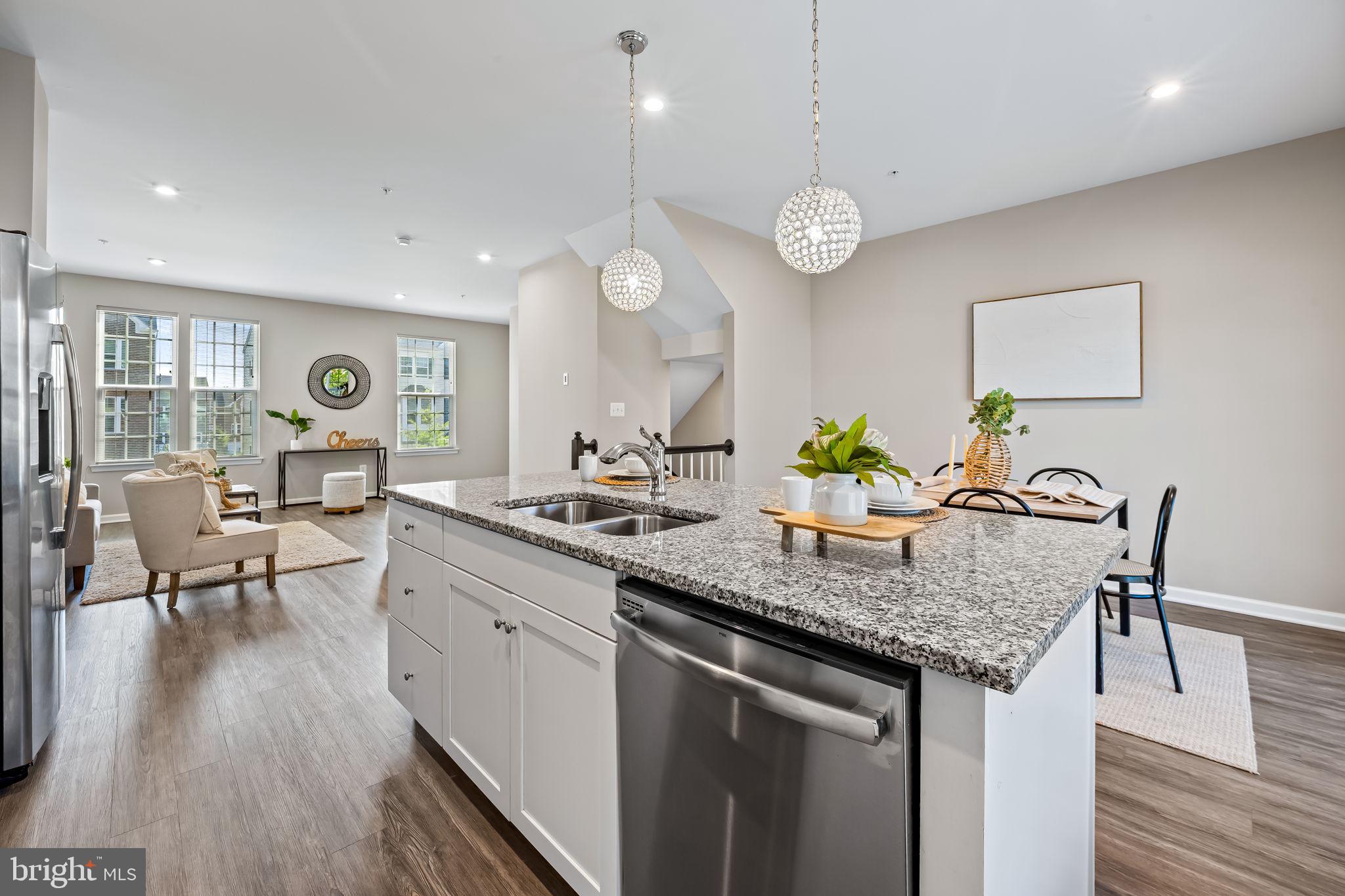 8206 Kirk Farm Circle Windsor Mill, MD 21244 - Photo 12 of 35 a kitchen with granite countertop a table chairs stove and wooden floor