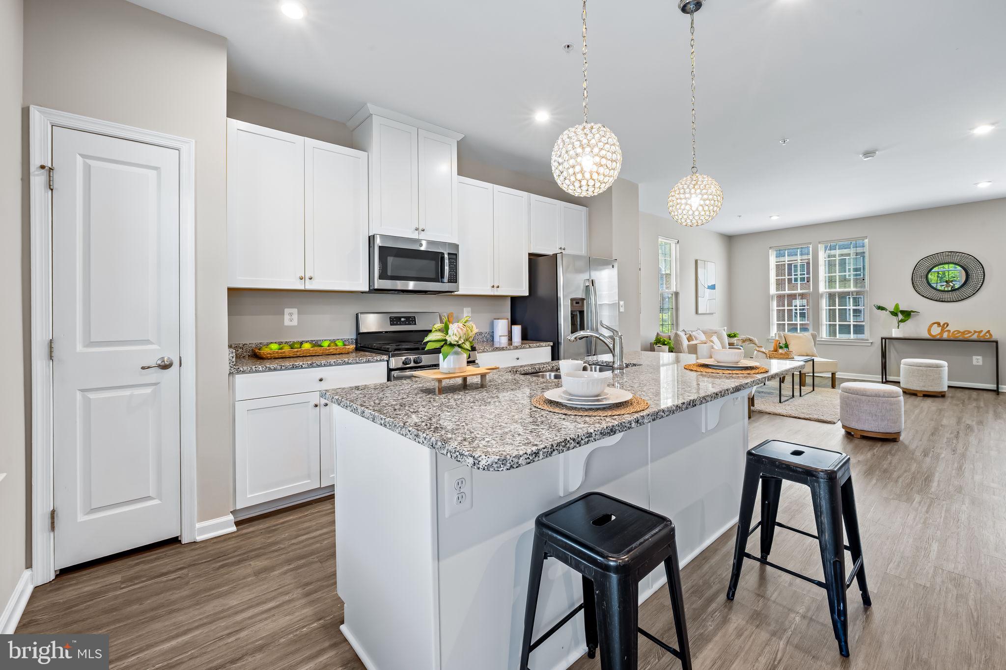 8206 Kirk Farm Circle Windsor Mill, MD 21244 - Photo 10 of 35 a kitchen with stainless steel appliances granite countertop a stove top oven a refrigerator a sink and white cabinets with wooden floor