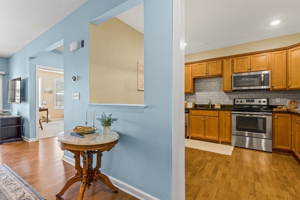 36 Abigail Way, Unit 3009 Reading, MA 01867 - Photo 4 of 36 a kitchen with stainless steel appliances a stove a sink a dining table and chairs