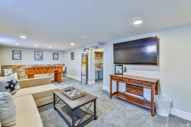 59 East 8680th Street South Sandy, UT 84070 - Photo 15 of 33 Spacious entertainment area featuring recessed lighting, gray carpeting, and a stone accent wall
