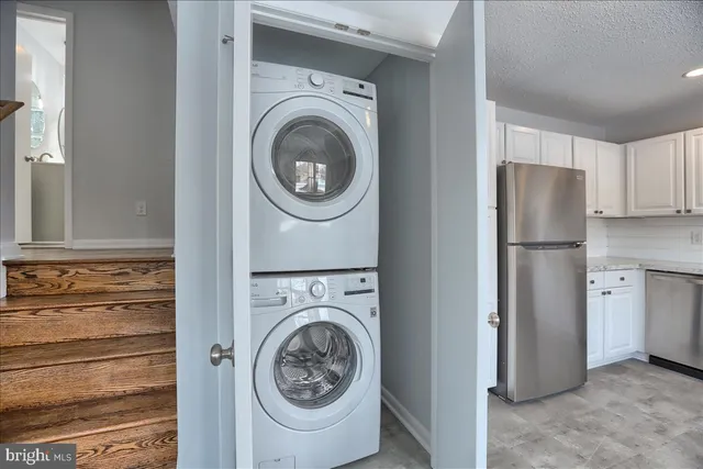 a view of a kitchen with refrigerator and cabinets