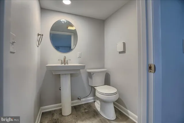 a bathroom with a toilet sink and mirror