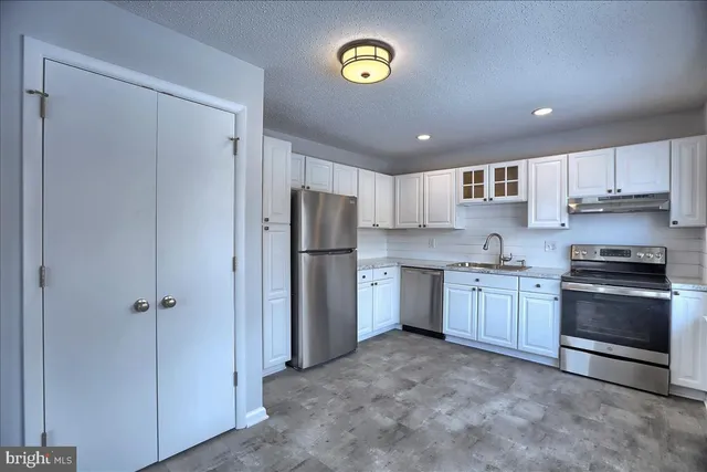a kitchen with a refrigerator a stove top oven a sink and dishwasher