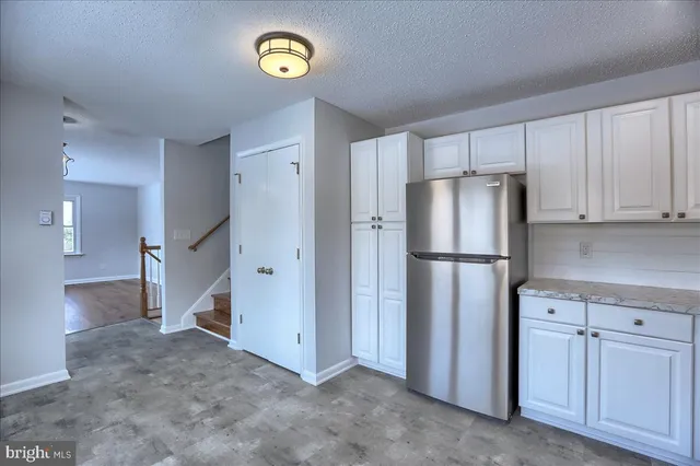 a view of a kitchen with closet and a refrigerator