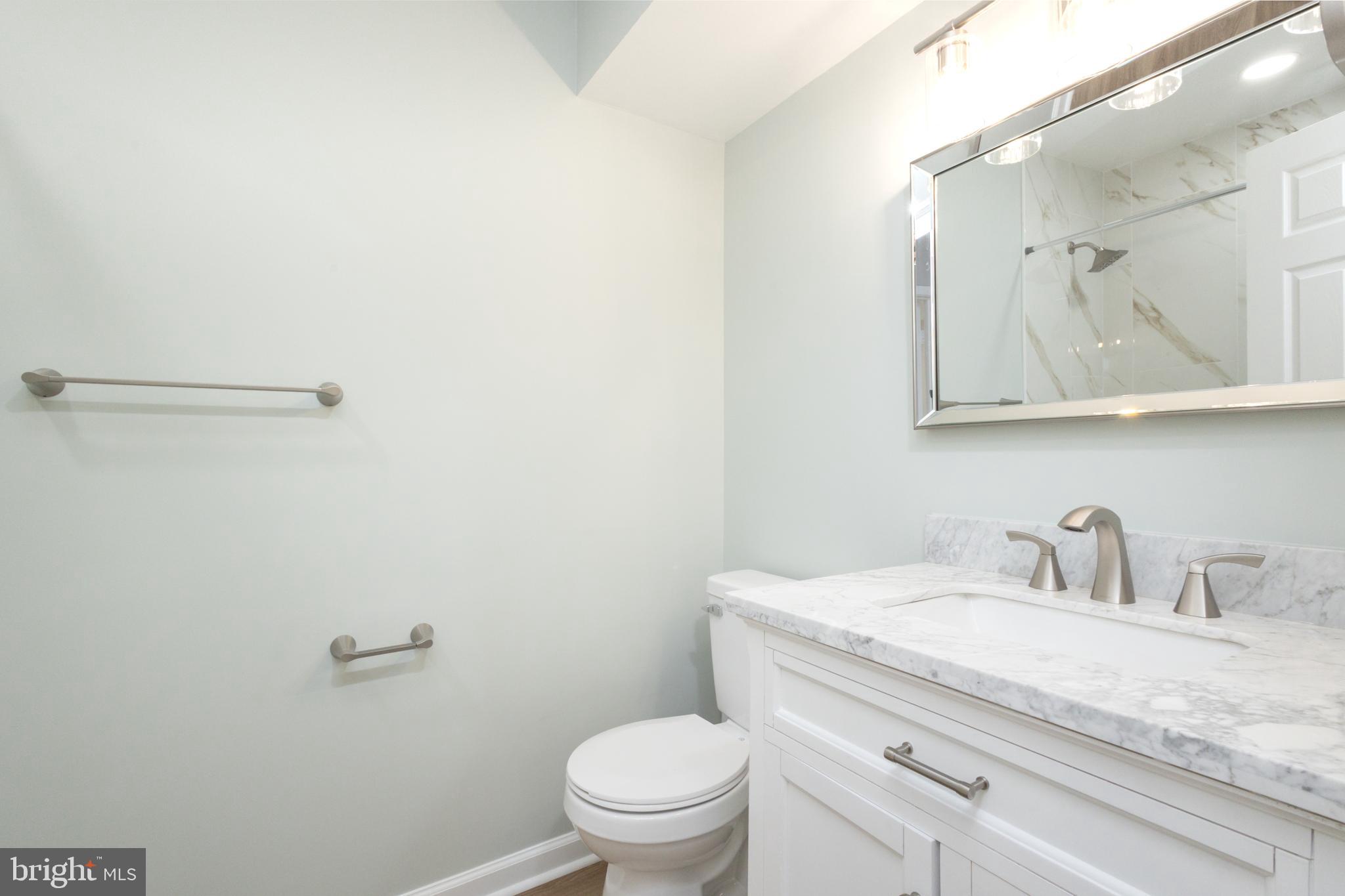8058 Felecity Court Springfield, VA 22153 - Photo 21 of 35 a bathroom with a granite countertop sink a toilet and a mirror