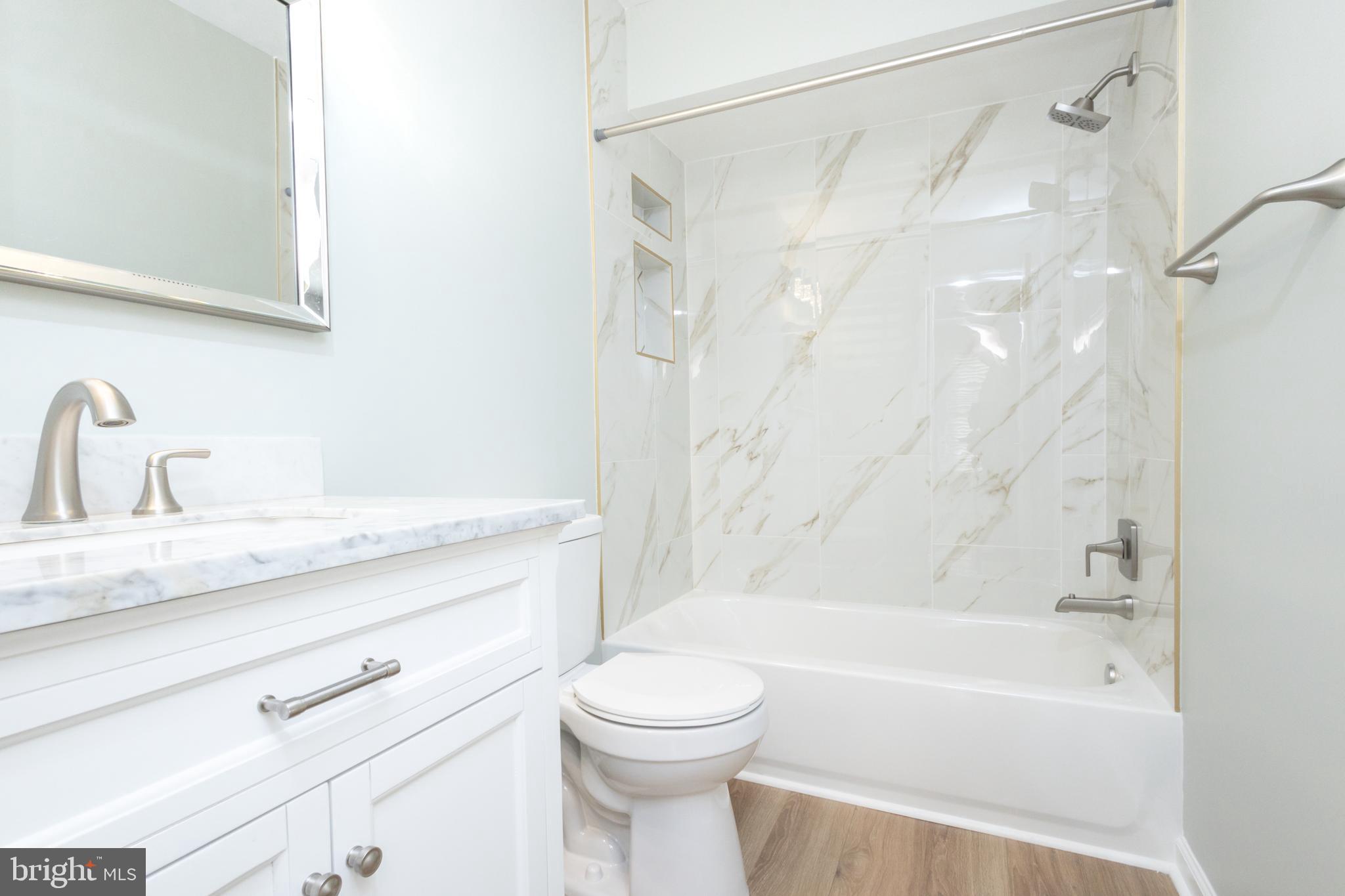 8058 Felecity Court Springfield, VA 22153 - Photo 25 of 35 a bathroom with a granite countertop sink a toilet and a bathtub