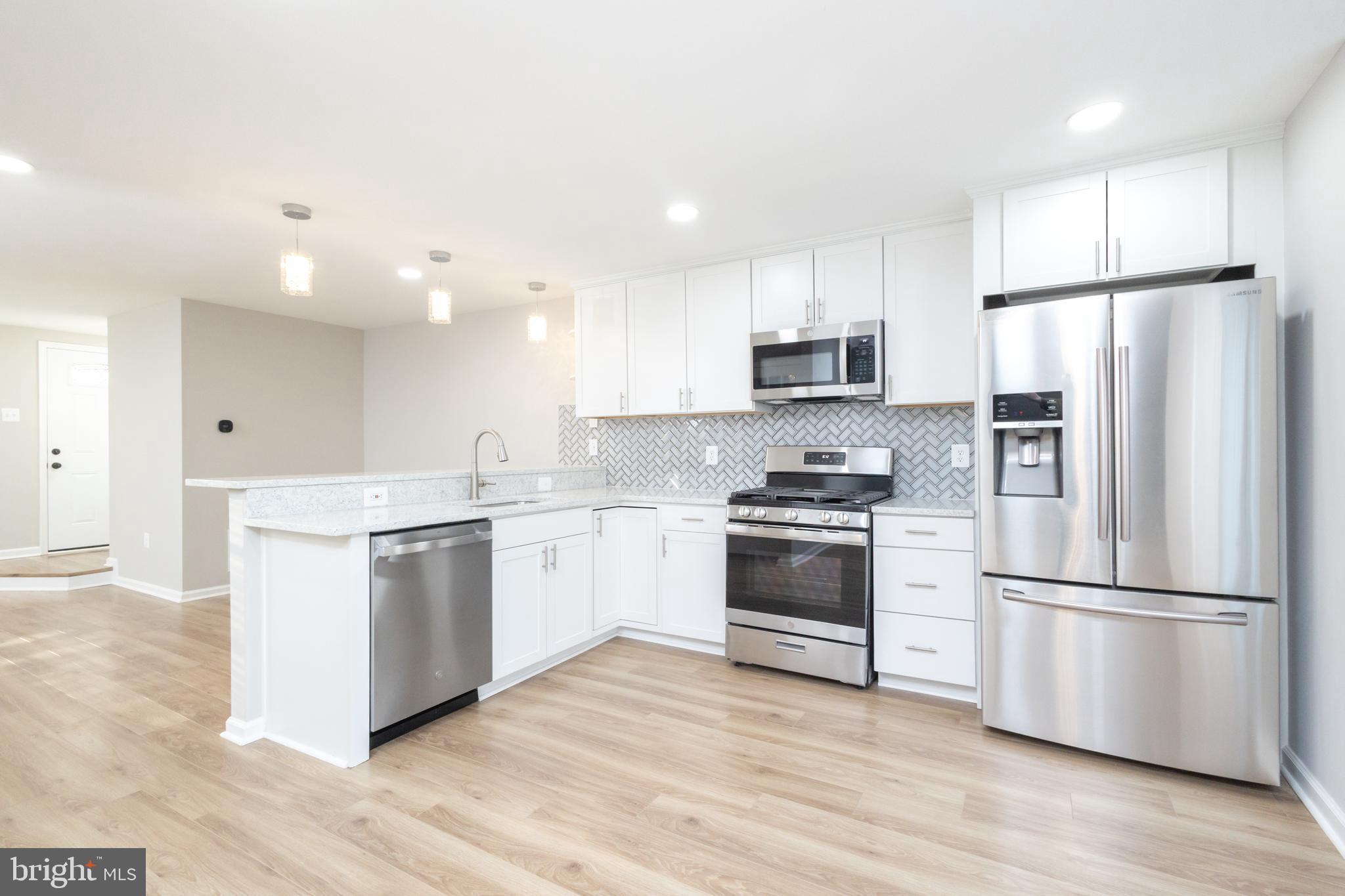 8058 Felecity Court Springfield, VA 22153 - Photo 6 of 35 a kitchen with granite countertop a refrigerator stove and wooden floor