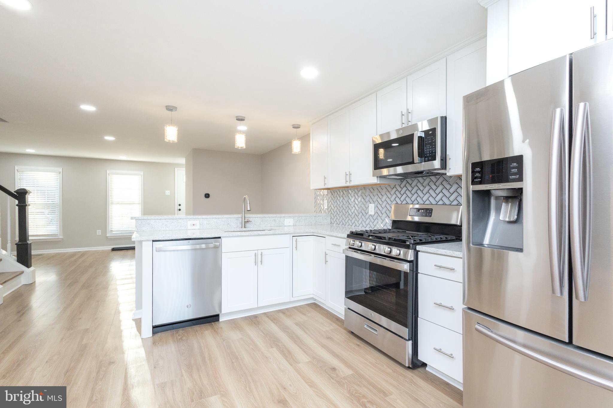 8058 Felecity Court Springfield, VA 22153 - Photo 7 of 35 a kitchen with stainless steel appliances kitchen island granite countertop a stove a refrigerator and a sink