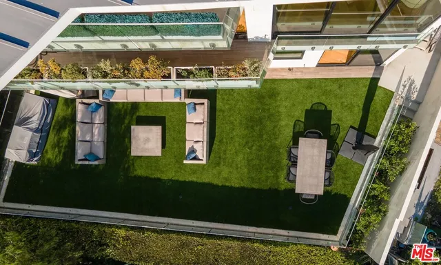 a living room with furniture kitchen view and a wooden floor