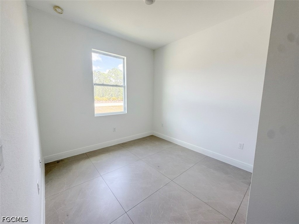 8753 Buckingham Road Lehigh Acres, FL 33971 - Photo 6 of 13 an empty room with a window