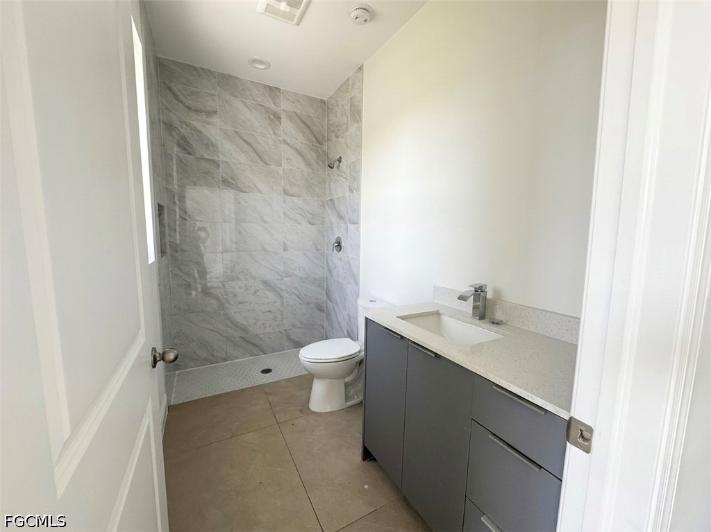 8753 Buckingham Road Lehigh Acres, FL 33971 - Photo 7 of 13 a bathroom with a granite countertop sink toilet and shower