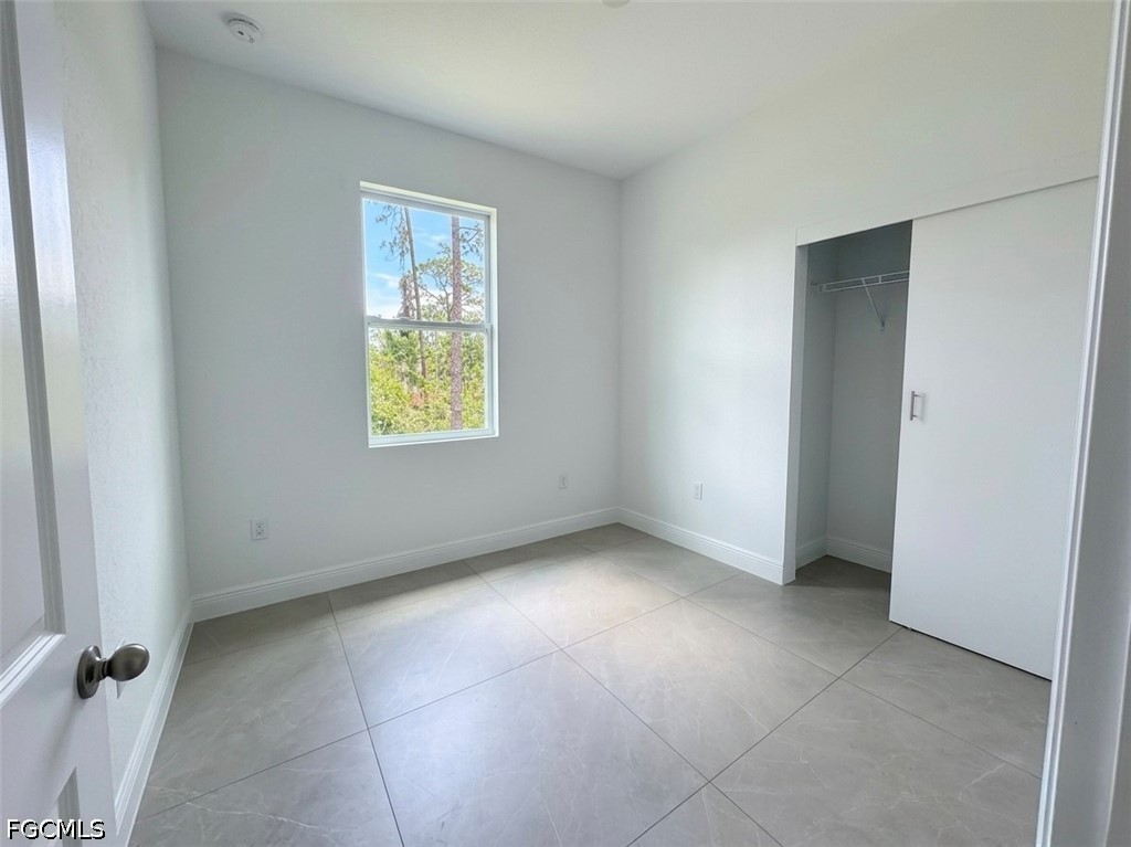 8753 Buckingham Road Lehigh Acres, FL 33971 - Photo 8 of 13 an empty room with windows