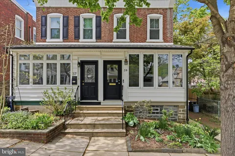 front view of a brick house with a large windows and a potted plant