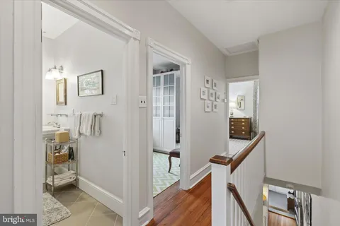 a view of a hallway with bathroom and wooden floor