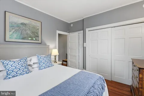 a bedroom with a bed and a painting on the wall