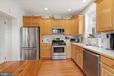 a kitchen with granite countertop a refrigerator stove top oven and sink