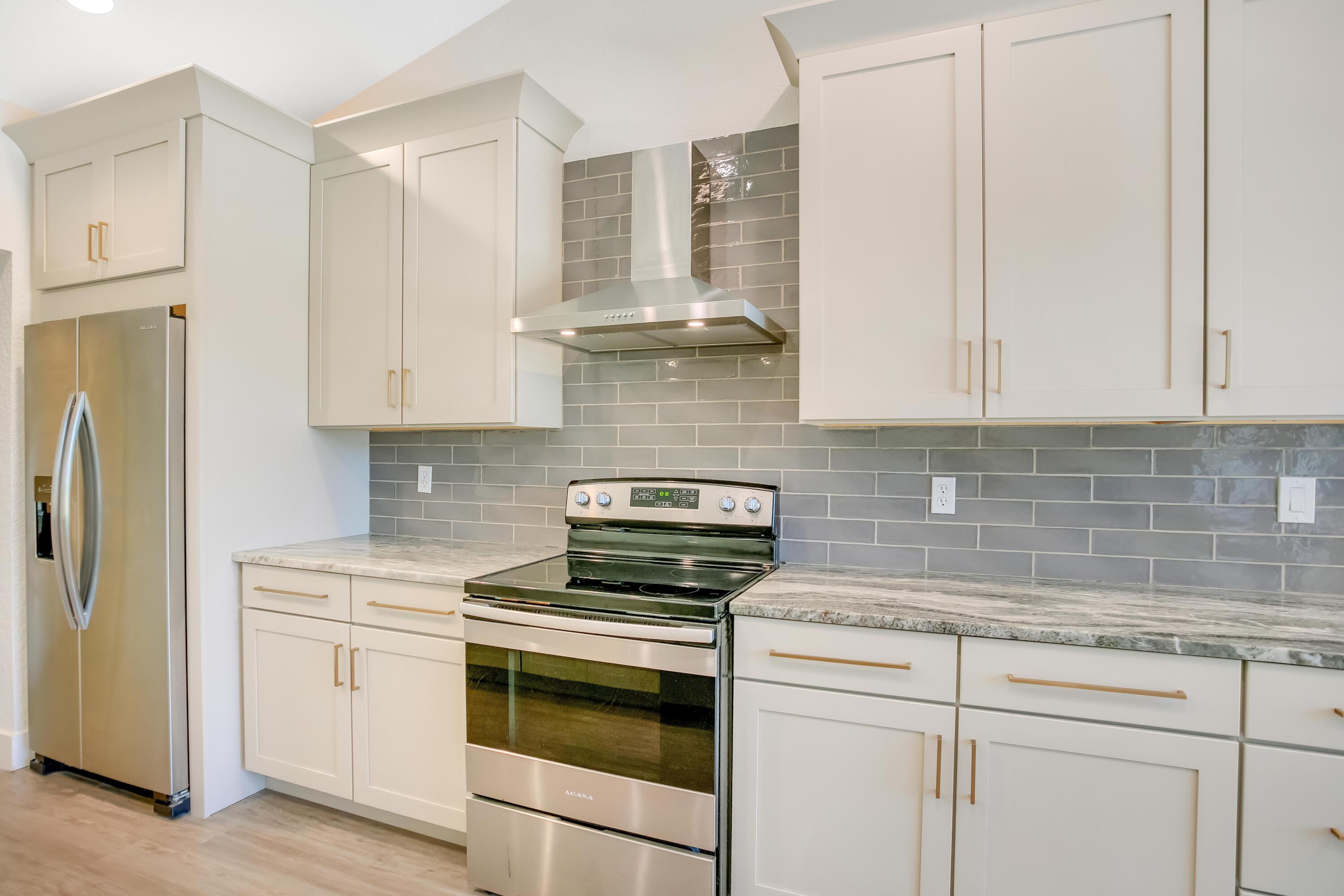 284 Shipwreck Road Santa Rosa Beach, FL 32459 - Photo 12 of 43 a kitchen with stainless steel appliances granite countertop white cabinets and a stove a refrigerator with white cabinets