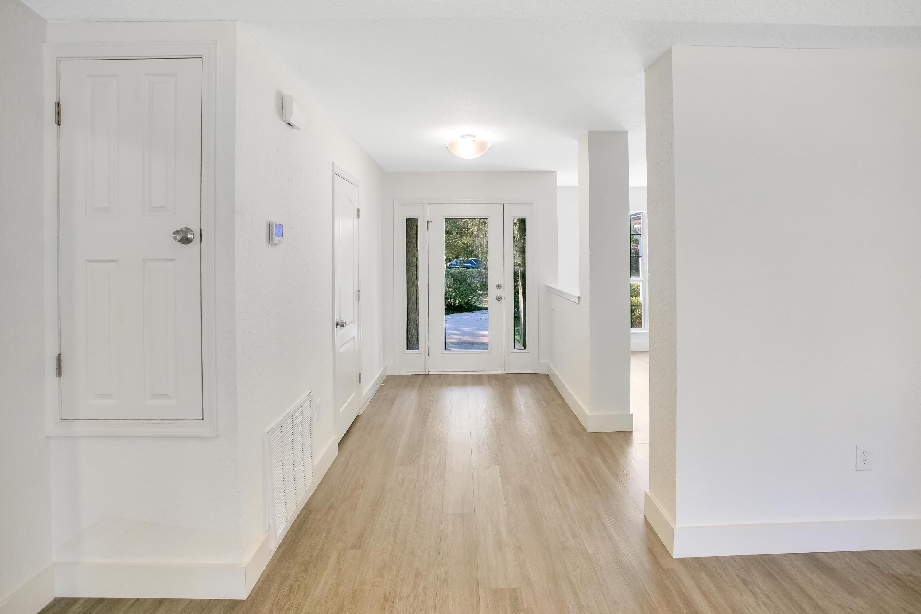284 Shipwreck Road Santa Rosa Beach, FL 32459 - Photo 5 of 43 a view of a hallway with wooden floor and closet area