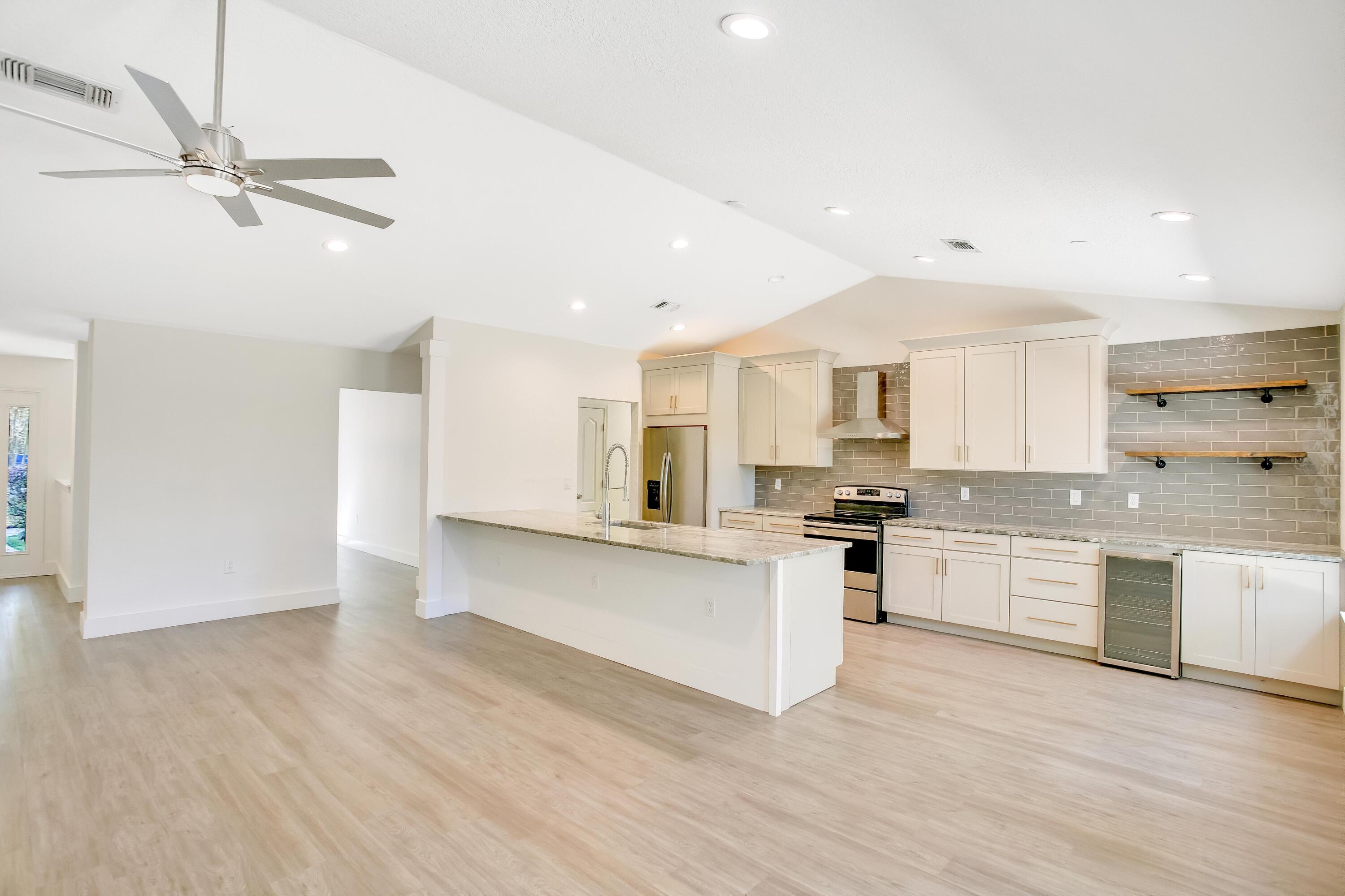 284 Shipwreck Road Santa Rosa Beach, FL 32459 - Photo 8 of 43 a large kitchen with kitchen island a sink stainless steel appliances and cabinets