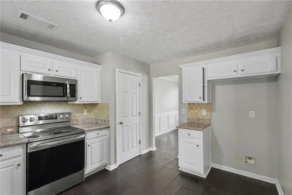 a kitchen with stainless steel appliances white cabinets and a stove