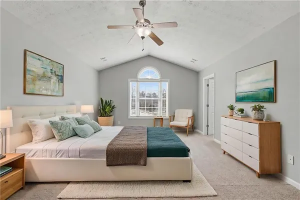 a bedroom with a large bed and a chandelier