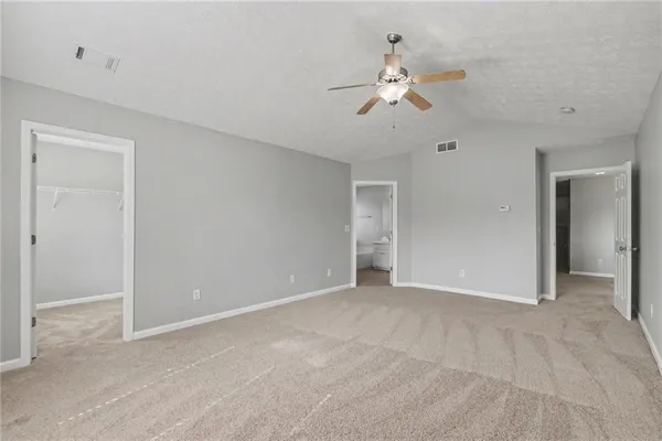 a view of an empty room with a chandelier fan