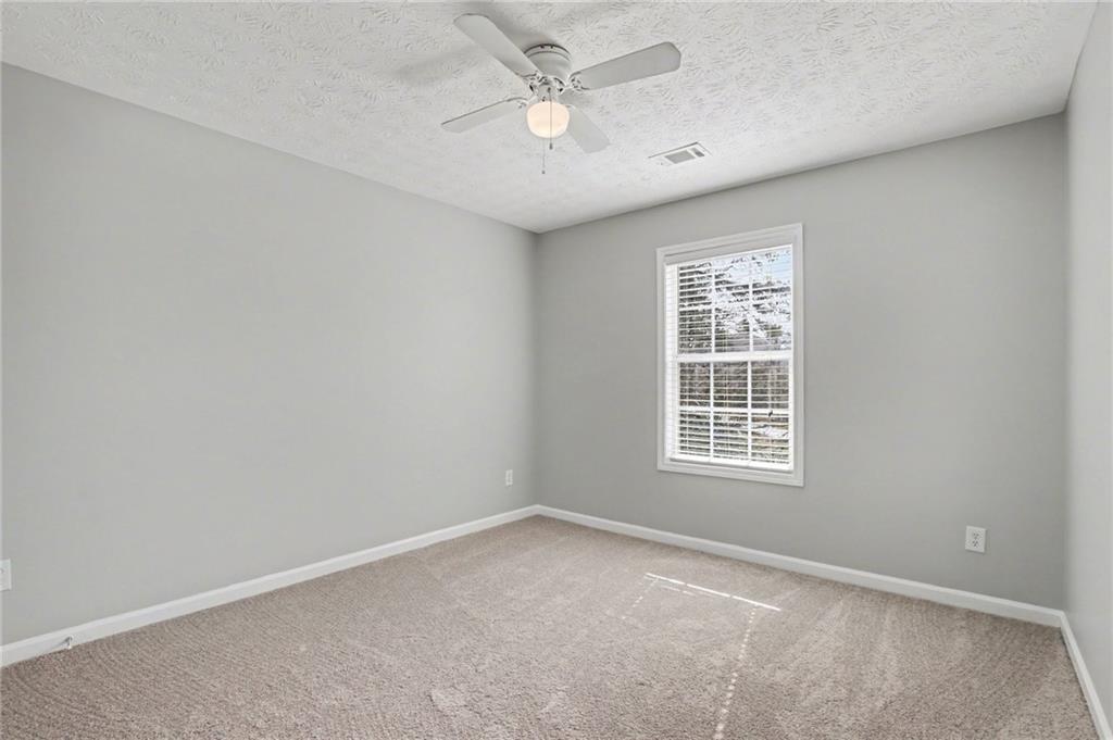 1259 Maxey Court Winder, GA 30680 - Photo 20 of 30 an empty room with a window and a ceiling fan
