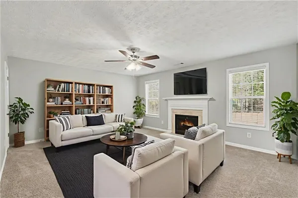 a living room with furniture a fireplace and a large window