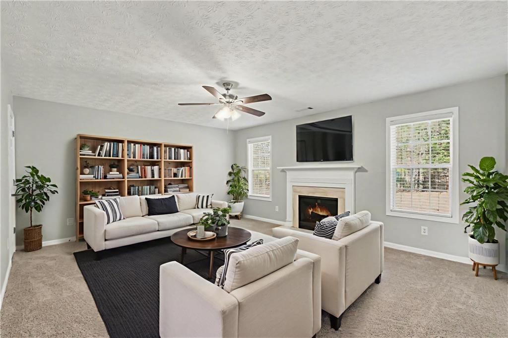 1259 Maxey Court Winder, GA 30680 - Photo 5 of 30 a living room with furniture a fireplace and a large window