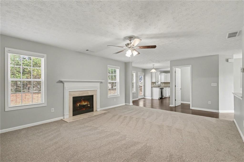 1259 Maxey Court Winder, GA 30680 - Photo 7 of 30 a view of an empty room with a fireplace and chandelier fan