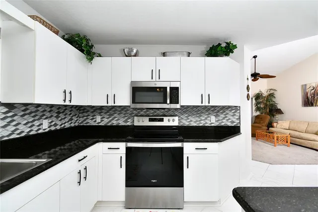 a kitchen with granite countertop a stove and a microwave