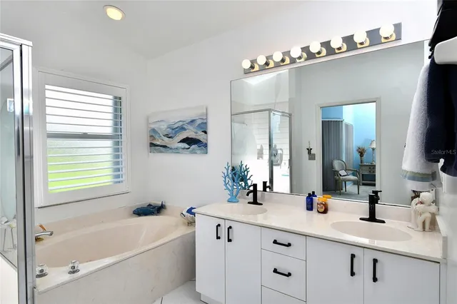 a bathroom with a tub a sink and mirror