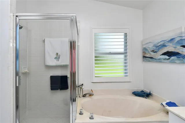 a bathroom with a bathtub a window and a shower