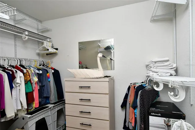 a view of walk in closet with clothes and shoes