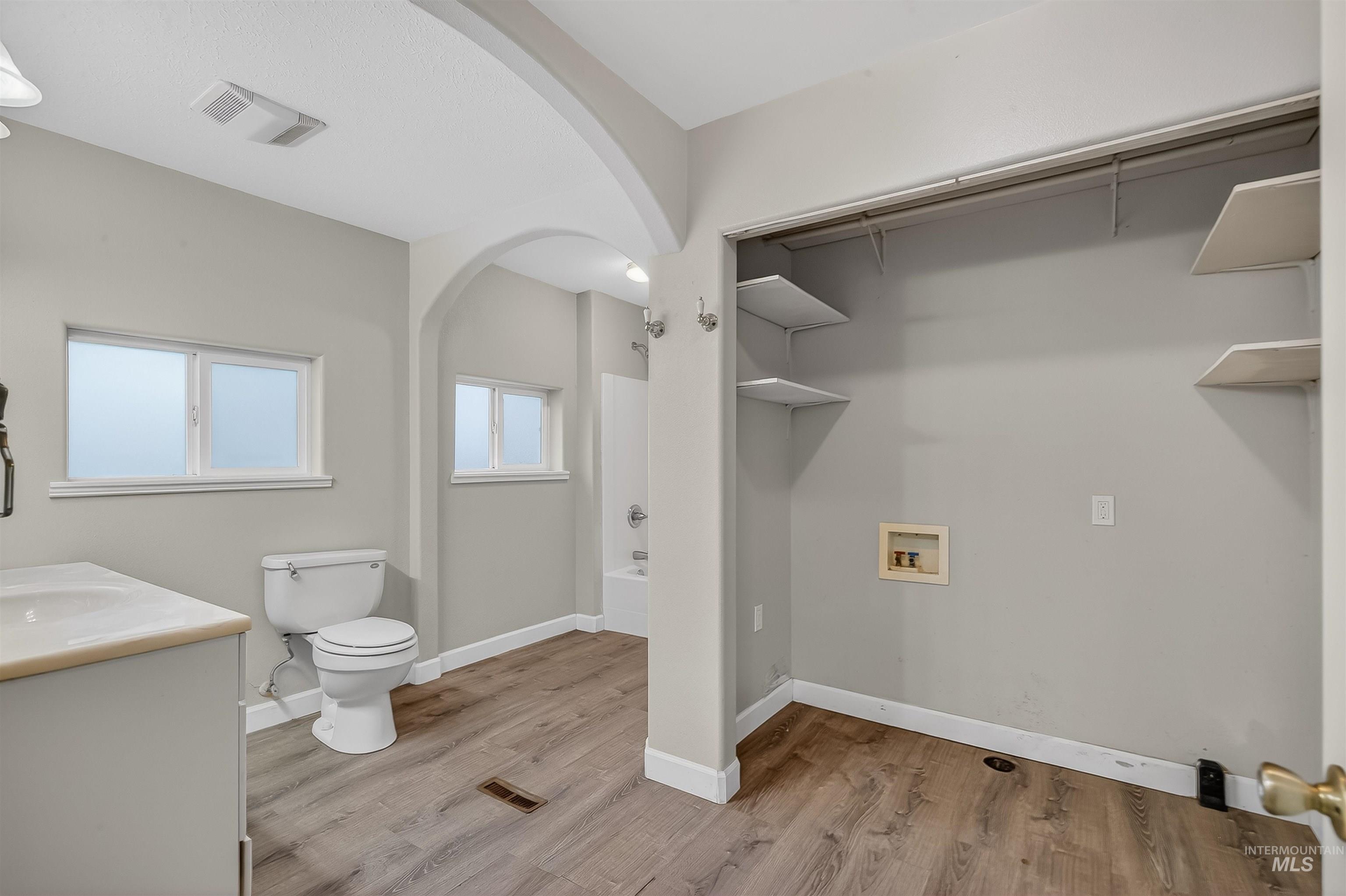 833 8th Street Clarkston, WA 99403 - Photo 16 of 40 Bathroom featuring vanity, light wood-style flooring, shower combination, and a walk in closet