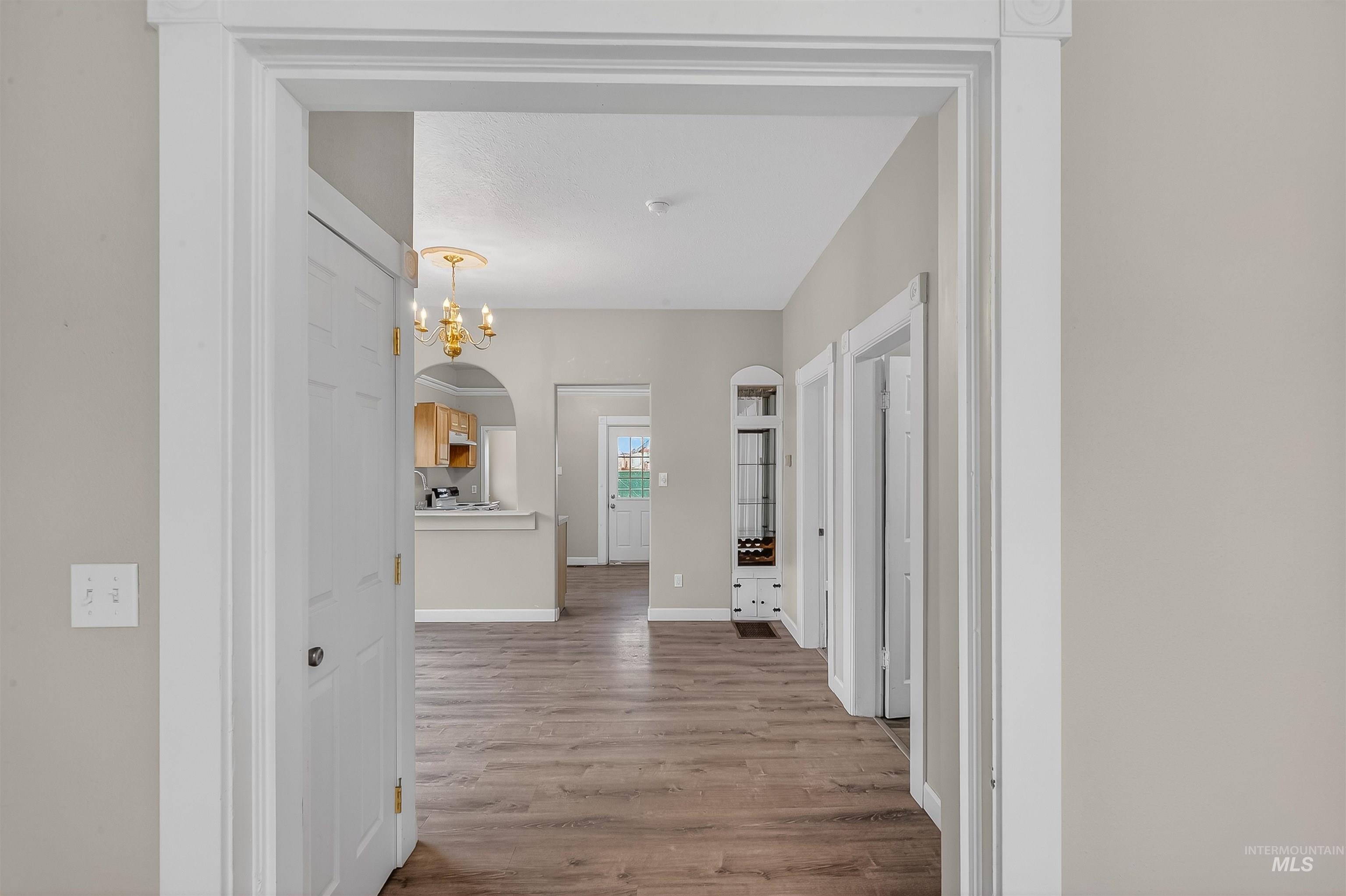 833 8th Street Clarkston, WA 99403 - Photo 21 of 40 Corridor with light wood finished floors, arched walkways, and a chandelier